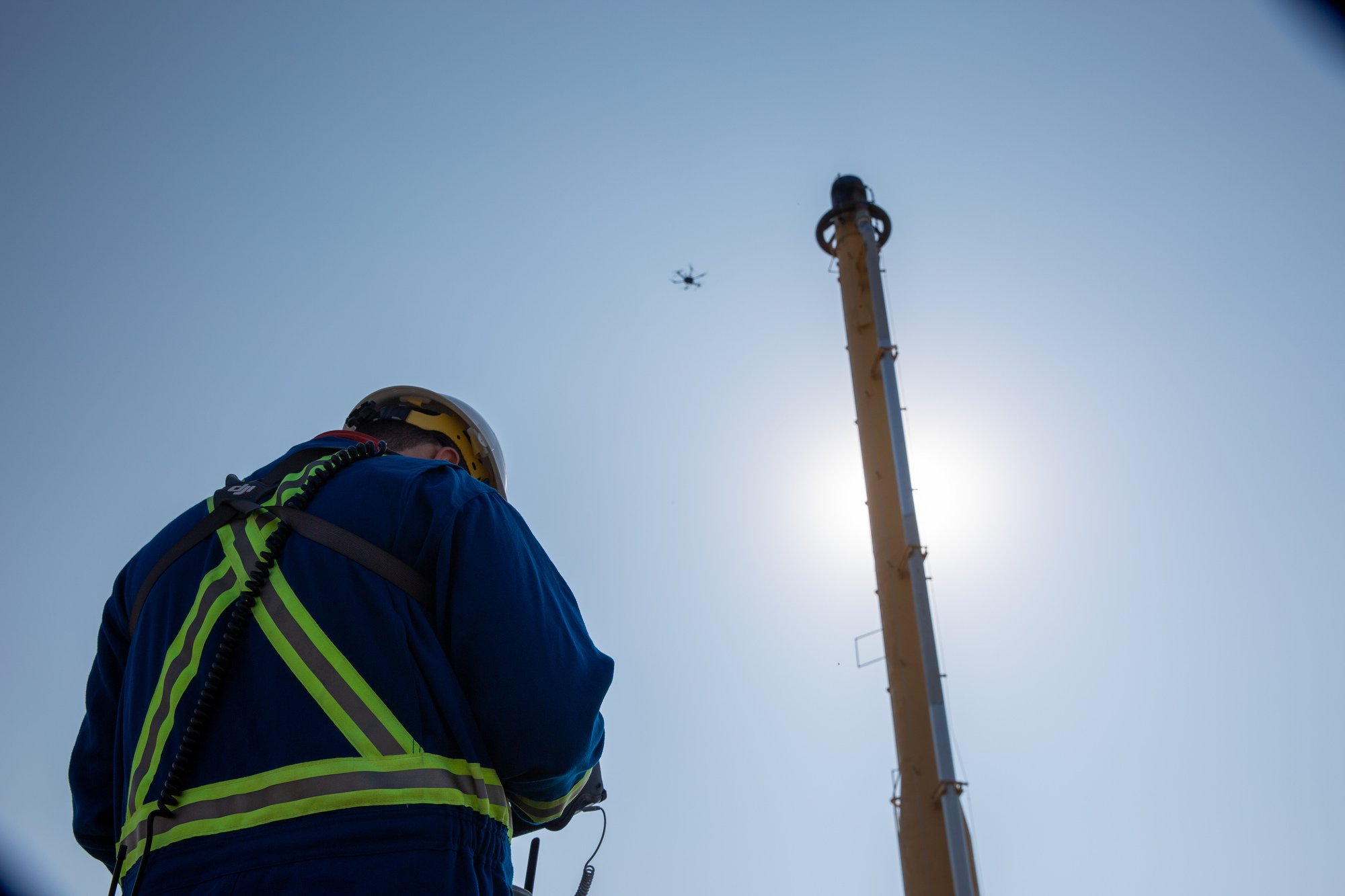 Worker piloting drone for flare inspection